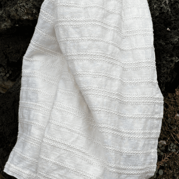 A folded cream-colored textured blanket.